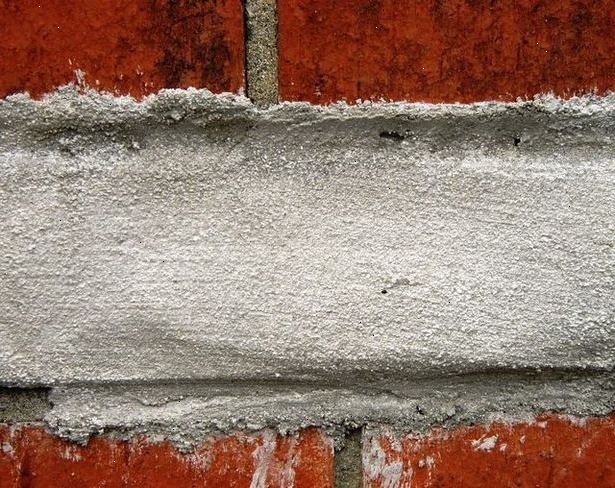 Hvordan å fylle hullene i murstein mørtel for Oppussing. Bruk børsten til å tømme ut små biter av rusk som du finner i sprekker.